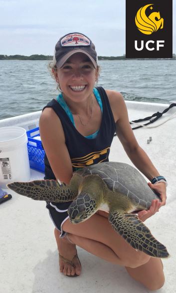 Andrea Krebs posing on a boat with a turtle